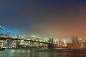 Manhattan skyline and Brooklyn bridge in mist at dusk, New York City, USA Manhattan skyline and Brooklyn bridge in mist at dusk, New York City, USA